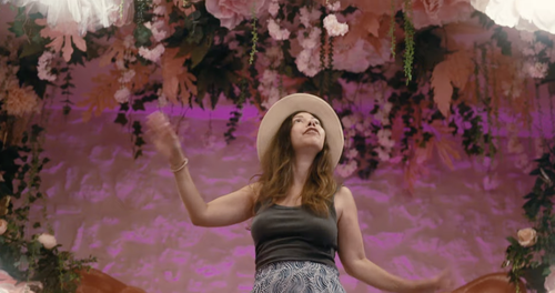 Mira dancing in a pink, flower-filled hotel room in Greece