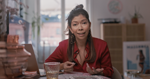 Mira telling her story at her dining table